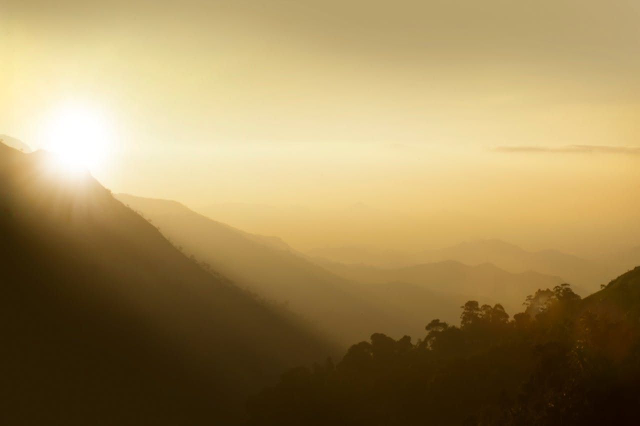 A beautiful sunrise over the misty mountains of Nuwara Eliya, Sri Lanka, showcasing nature's serene beauty.